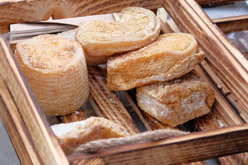 Farmers traditional cheese in wooden box is sold at local country market. Cheese manufacture.