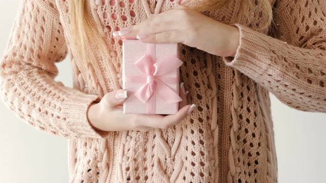 girl holding and stroking a present in a gift box. surprise congratulation celebration reward gratitude concept.
