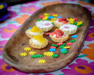 multiple colorful cupcakes of different flavors on a colorful background