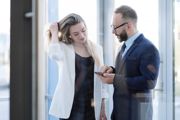 A man and a woman at the entrance to the office door are talking, acquaintance.