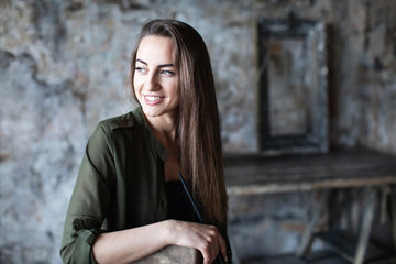 Smiling long-haired woman sitting and looking away.