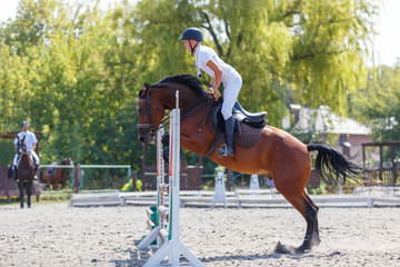 Young man riding horse on show jumping event. Sportsman on his course in equestrian competition