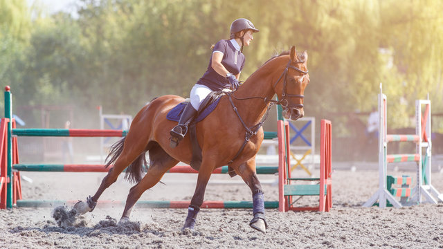Young woman riding horse on her course in show jumping equestrian competition
