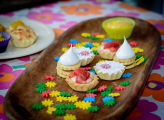multiple colorful cupcakes of different flavors on a colorful background