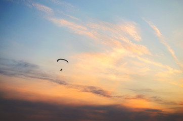 Ione paraglider flies high in the sky at sunset.Extreme sport.