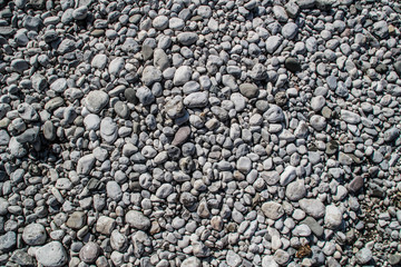 The texture of white river stones. The river of Slovenia with blue water