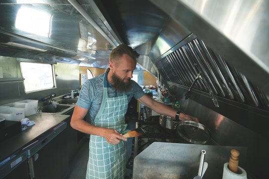 Waiter preparing food in food truck - Powered by Adobe