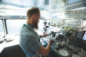 Waiter preparing coffee in food truck