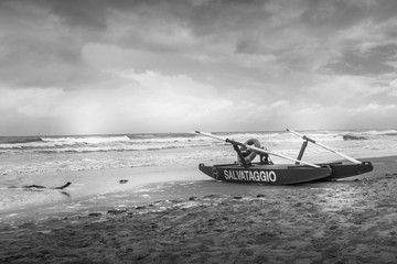 rescue boat in black and white on beach on a bad weather day