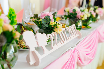 a table for newlyweds with a wooden plate on which date of the w