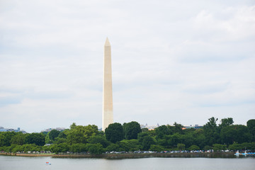 The Washington Monument and tidal basin in summer. A peddleboat is in the water. 