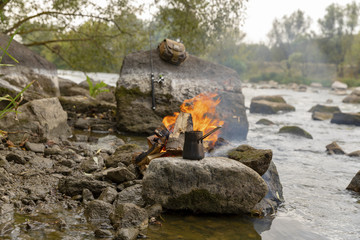 Fishing is a hobby. A bonfire on the bank of the river. Fishing on the bank of a river or a lake. Fishing and recreation in nature. Hiking. Traveling on the river bank.