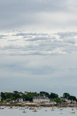 vue verticale sur des battisses au bord de la mer en Bretagne avec des bateaux sur l'eau