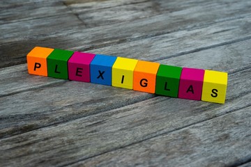 Farbige Holzwürfel mit Buchstaben auf dem das Wort Plexiglas abgebildet ist, Abstrakte Illustration