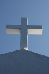 Cycladic greek orthodox church on Paros island, Greece. White cross against blue sky