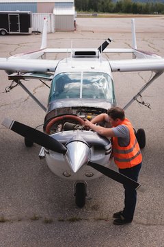 Engineer servicing aircraft engine near hangar