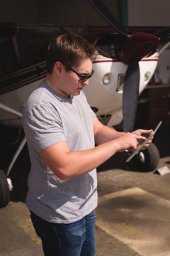 Man using digital tablet at hangar
