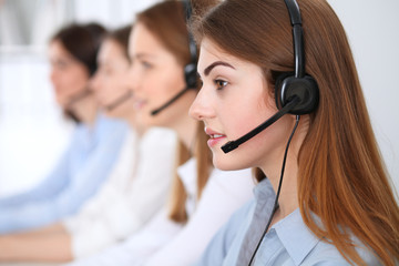 Call center. Beautiful cheerful smiling operator consulting clients with headset. Business concept...