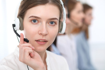 Call center. Beautiful cheerful smiling operator consulting clients with headset. Business concept...
