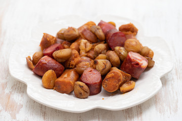 portuguese smoked sausages with chestnuts on white dish