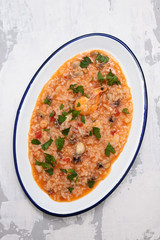rice with seafood and herbs on white dish