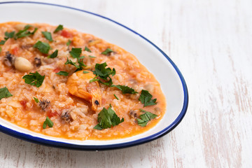 rice with seafood and herbs on white dish