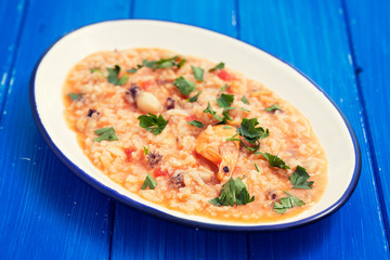 rice with seafood and herbs on white dish