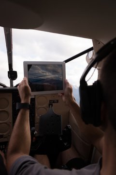 Pilot taking photos with digital table while flying