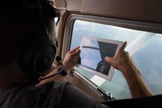 Pilot taking photos with digital table while flying