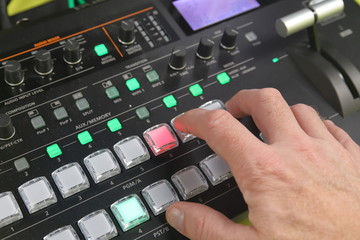 Hand operating video production switcher, A/v buttons