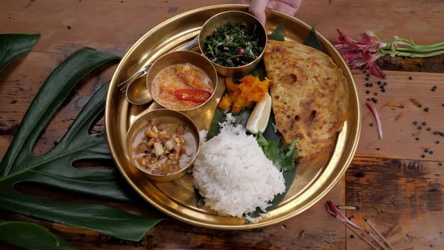 Assorted indian sri-lanka food set on wooden background. Dishes and appetisers of indeed cuisine, rice, lentils, paneer, samosa, spices, masala. Bowls and plates with indian food top view chicken