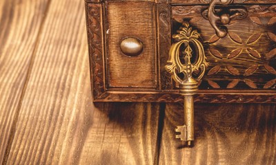 Old casket and key on wooden desk