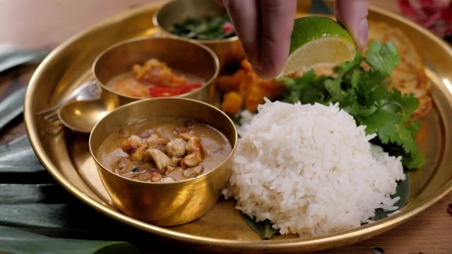 Assorted indian sri-lanka food set on wooden background. Dishes and appetisers of indeed cuisine, rice, lentils, paneer, samosa, spices, masala. Bowls and plates with indian food top view chicken