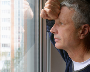 Grieving Man looking through a window