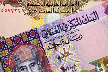 A close up image of an Omani one rial note with a United Arab Emirates five Dirham bill