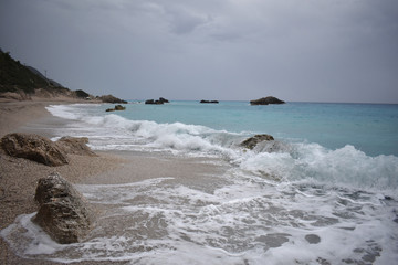 blue sea, waves and sand, and cloudy skies