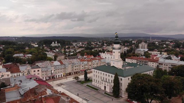 Aerial view of downtown of Drohobych city, Ukraine. Architecture, city hall, central square, cathedral of the Holy Trinity, panoramic view of city. Smooth flight straight and up