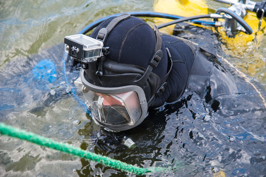 Diver in a diving suit and helmet ready to dive