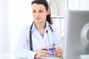 Young brunette female doctor at working place in  hospital. Health care, insurance and help concept