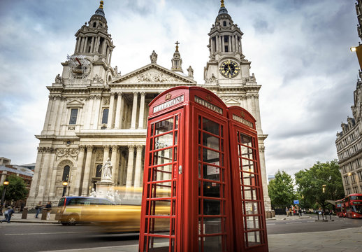red phone boxes and yellow car passing Saint Paul's Cathedral in London at cloudy day © offcaania