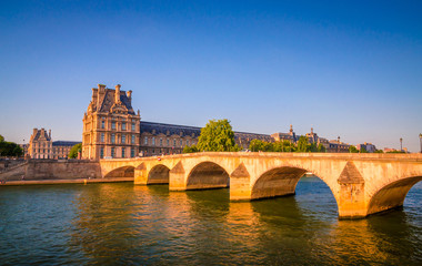 Obraz premium Sunset view on bridge and buildings on the Seine river in Paris, France