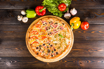 4 kinds of pizza in one - salami, bacon, tomatoes, ham. Creative author's pizza home made.