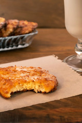 Breakfast of cottage cheese cookies with milk, vertical frame, wooden background.