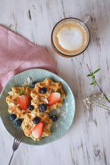 Belgian waffles Healthy breakfast concept blueberry strawberry Cappuccino coffee white wooden background Eucalyptus Branch Top view Flat lay
