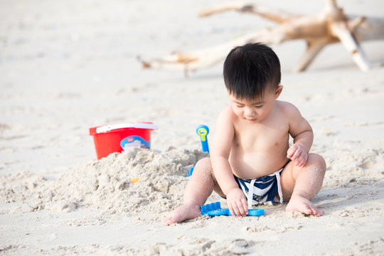 First year old boy play with sand, Taking baby to the beach concept