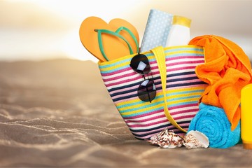 Colorful towels, cosmetics bottles and soap in basket, isolated