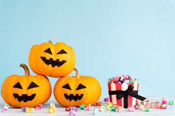 Yellow ghost pumpkin with paper star in cup on sky blue background. halloween concept.