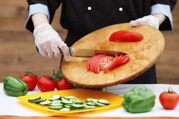 The cook cuts fresh farm vegetables