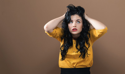 Young woman feeling stressed on a solid background