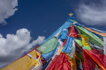 Tibetan prayer flags against sky and clouds in Qinghai, China